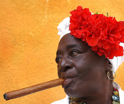 Frau mit Blumenhut und einer großen Zigarre in Havanna